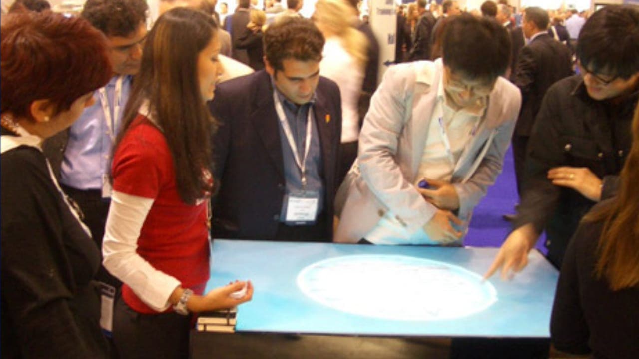 Conference visitors playing the AMO game on an interactive touch table