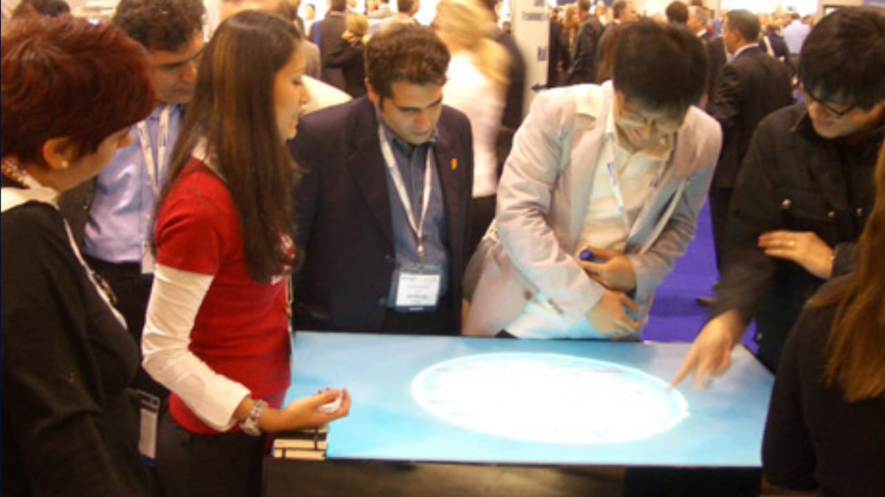 Conference visitors playing the AMO game on an interactive touch table